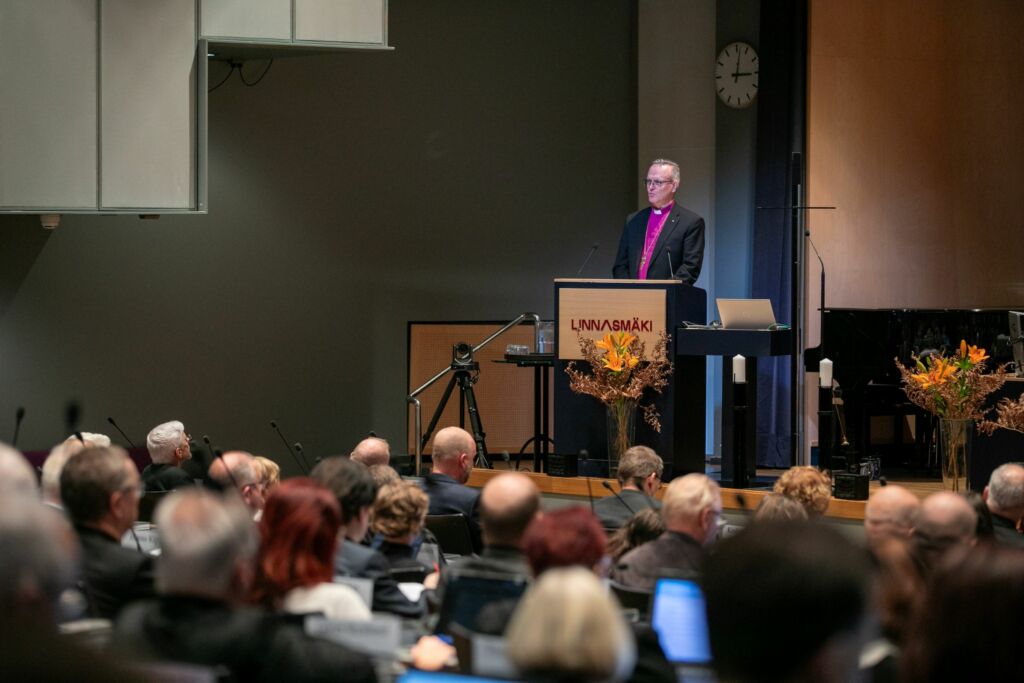 Arkkipiispa puhuu kirkolliskokousväelle.